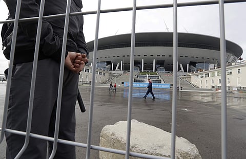 In this file photo dated Saturday, Sept. 10, 2016, a security man stands guard at the soccer stadium on Krestovsky Island which will host some 2018 World Cup matches, under construction in St.Petersburg, Russia. | AP