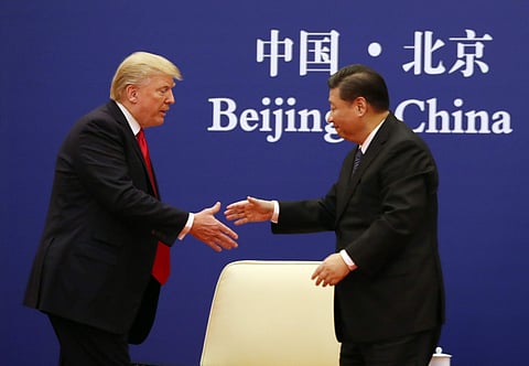 US President Donald Trump, left, and Chinese President Xi Jinping prepare to shake hands during a business event at the Great Hall of the People in Beijing, Thursday, Nov. 9, 2017. (AP Photo/Andrew Harnik)