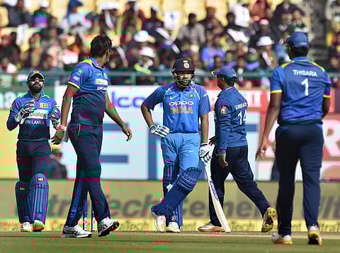Sri Lanka's Suranga Lakmal and his teammates look on as Indian captain Rohit Sharma wait for 3rd umpire'a decision on his dismissal during the first ODI cricket match at the HPCA Stadium in Dharamshala. | PTI