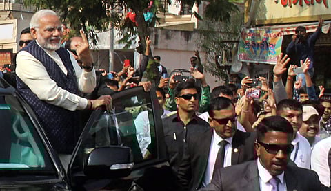 PM Modi shows his finger marked with indelible ink as he leaves after casting his vote during the second phase of state Assembly elections at Ranip in Ahmedabad on Thursday. (PTI)