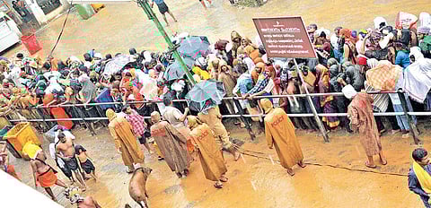 Braving heavy rain, pilgrims wait in jampacked queue for darshan of Lord Ayyappa at Sabarimala on Friday | SHAJI VETTIPURAM