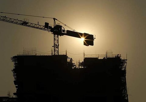 Workers fasten steel rods together atop a residential building under construction in Mumbai. (Photo | Reuters)