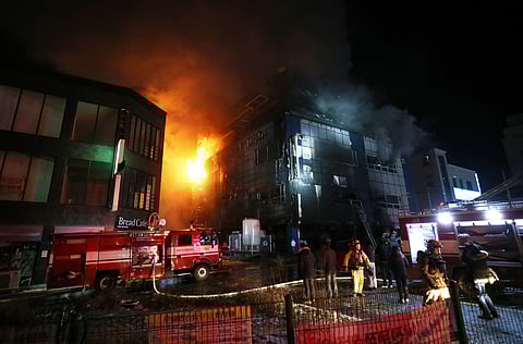 Firefighters try to extinguish a fire at an eight-floor building in Jecheon, South Korea. | AP