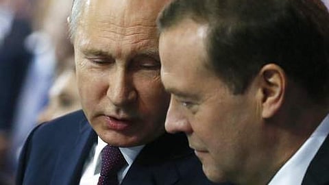 Russian President Vladimir Putin, left, speaks to the then Prime Minister Dmitry Medvedev during the United Russia party congress in Moscow, Russia, Saturday, Dec. 23, 2017.