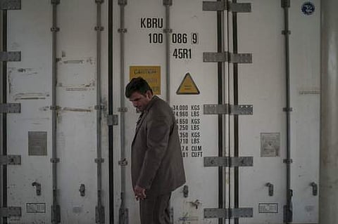 In this Nov. 8, 2017 photo, senior examiner Modhar al-Omari stands outside a refrigerated container carrying dozens of bodies in a morgue in Mosul, Iraq. | AP