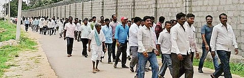 Protesting Vemulaghat farmers walking towards chief minister's farmhouse in Erravalli. (Express Photo)