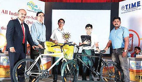 (from left) Ajay Antony, quiz master & vice president T.I.M.E., M Pramod Kumar, center director Kochi, with the winners Madhav Pramod and Anirudh P S of Choice School, Tripunithura