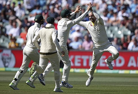Australia's Nathan Lyon, right, celebrates with teammates after catching out England's Moeen Ali for 25 runs during the third day of their Ashes Test match in Adelaide, Monday, Dec. 4, 2017. | AP