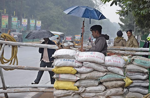A security guard on Assembly duty takes shelter under an umbrella in Bhubaneswar as depression induced rain on Friday | shamim qureshy