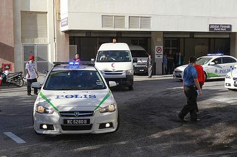 Police officers wait at the forensic department entrance at a hospital in Putrajaya, Malaysia on Wednesday, Feb. 15, 2017. AP