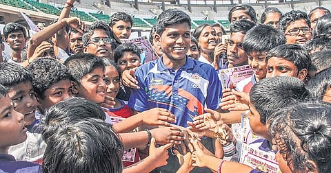 Paralympic high jumper Mariyappan Thangavelu is surrounded by students at a school event at JN Stadium on Wednesday | Ashwin Prasath