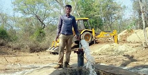 Forest staffer filling water in a waterhole for wild animals | Express