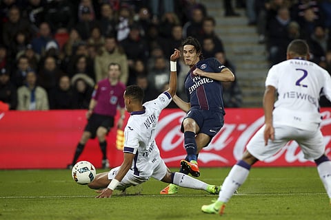 PSG's Edinson Cavani, center, shoots past Toulouse's Christopher Jullien during their League One soccer match, at the Parc des Princes stadium, in Paris, France, Sunday, Feb. 19, 2017. | AP