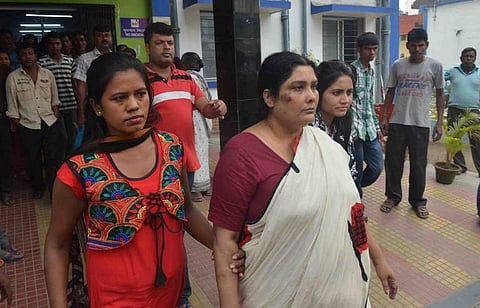 Indian police and CID officials escort Chandana Chakraborty (L) from a police station in Siliguri on February 22, 2017, for a medical check up to Siliguri hospital in the eastern Indian state of West Bengal, after her arrest as part of an alleged child tr