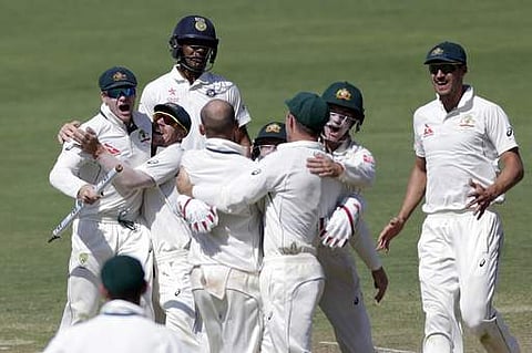 Australia's captain Steve Smith, left, and David Warner, second left, celebrate after winning the first cricket test match against India in Pune. | AP