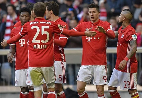 Bayern Munich's Polnish striker Robert Lewandowski (2ndR) celebrates his second goal with his teammates during the German first division Bundesliga football match against Hamburger SV. | AFP