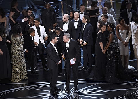 Host Jimmy Kimmel, left, and presenter Warren Beatty discuss the results of best picture as the casts of 'La La Land' and 'Moonlight,' winner of best picture, react on stage at the Oscars on Sunday, Feb. 26, 2017, at the Dolby Theatre in Los Angeles. (Pho