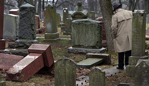 People walk through toppled graves at Chesed Shel Emeth Cemetery in University City, Missouri, on February 21. (File Photo | AP)