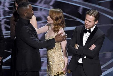 Ryan Gosling, right, stands with his arms folded as Emma Stone, center, congratulates Mahershala Ali, for winning the award for best picture for 'Moonlight' at the Oscars on Sunday, Feb. 26, 2017 (Photo | AP)