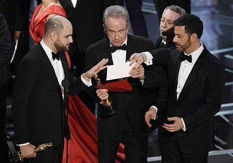 'La La Land' producer Jordan Horowitz, left, presenter Warren Beatty, center, and host Jimmy Kimmel right, look at an envelope announcing 'Moonlight' as best picture at the Oscars. AP