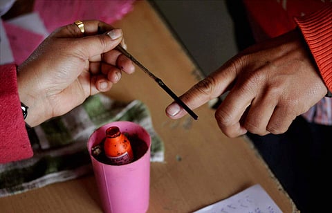 The indelible ink is applied to a finger of a voter at a polling station in a village about 25 km from Amritsar on Saturday. | PTI