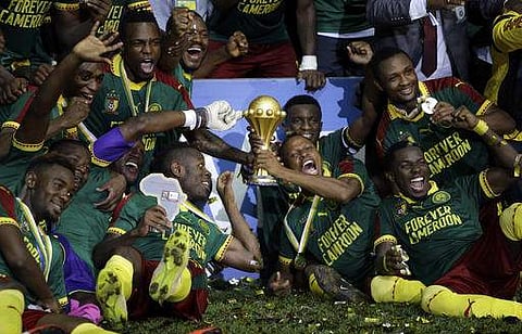 Cameroon players celebrate with the trophy after winning the African Cup of Nations final soccer match between Egypt and Cameroon at the Stade de l'Amitie. | AP