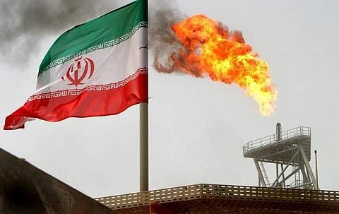 Gas flare on an oil production platform in the Soroush oil fields is seen alongside an Iranian flag in the Gulf. (Photo | Reuters)
