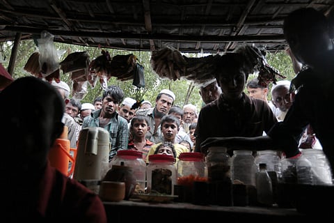 In this Dec. 2, 2016 file photo, Rohingya from Myanmar watch a television program about them being shown on a mobile phone inside a tea stall at an unregistered refugee camp in Teknaf, near Cox's Bazar, a southern coastal district about, 296 kilometers (1