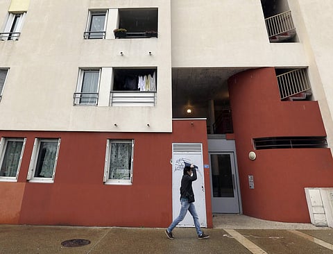 A man passes by an apartment building where suspects believed to be involved in plotting an attack were arrested by a French anti-terrorist police unit in Montpellier, southern France, Friday, Feb. 10, 2017. | AP