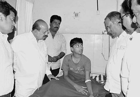 Chikkanayakanahalli JD(S) MLA C B Suresh Babu and Law Minister T B Jayachandra speaking to Sudarshan, who survived the incident, in Tumakuru on Thursday