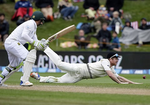 New Zealand's Jimmy Neesham, right, dives to stop take the ball as South Africa's Dean Elgar watches during day four of the first cricket test at University Oval, Dunedin, New Zealand, Saturday, March 11, 2017. | AP