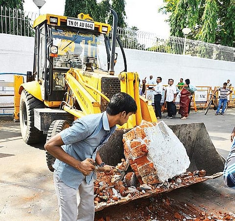 An earthmover clearing the debris from the spot where a car rammed a mini lorry on the Gemini flyover on Wednesday morning | Romani Agarwal