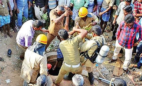 Fire and rescue department personnel pull out the bodies of the three contract workers who died in the manhole on Monday | Express