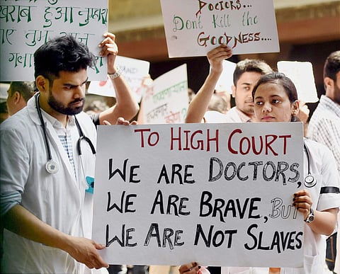 Resident doctors show placards during a protest rally at the KEM hospital demanding security after a intern was assaulted by patient's relatives in Mumbai . (File | PTI)
