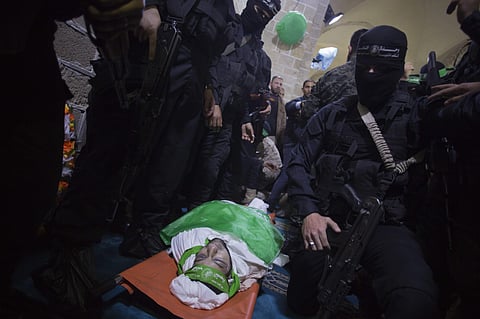 Masked gunmen from the Qassam brigade, the militia wing of Hamas, surround the body of Mazen Faqha, during his funeral in Gaza City, Saturday, March, 25, 2017. (Photo | AP)