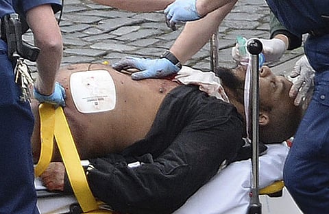 The attacker Khalid Masood is treated by emergency services outside the Houses of Parliament London. AP