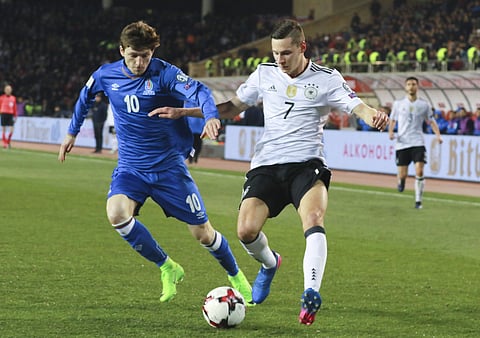 Germany's Julian Draxler, right, and Azerbaijan's Ruslan Gurbanov challenge for the ball during their World Cup Group C qualifying match at the Tofig Bahramov Stadium in Baku, Azerbaijan, Sunday March 26, 2016. | AP