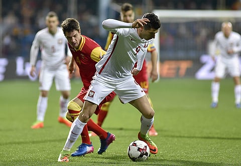 Poland's Robert Lewandowski, right, challenges Montenegro's Nikola Vukcevic, during their World Cup Group E qualifying soccer match at the City Stadium in Podorica, Montenegro, Sunday, March 26, 2017. | AP