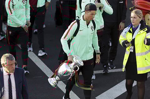 Portugal's Cristiano Ronaldo carries the Euro 2016 European soccer championship trophy as the Portugal team arrives at the Madeira airport outside Funchal. (Photo | AP)