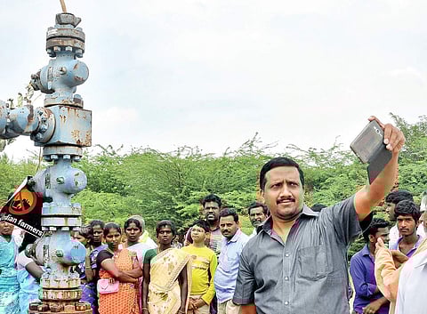 A man taking a selfie in front of the ONGC exploratory well at Nallankollai near Neduvasal in Pudukkottai district. | Express File Photo