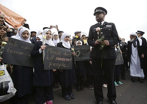 A police officer stands next to muslim girls during a commemorative event to mark last week's attack outside Parliament. (Photo | AP)