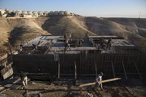 Palestinian laborers work at a construction site in a new housing project in the Israeli settlement of Maale Adumim, near Jerusalem on February 7. (File Photo | AP)