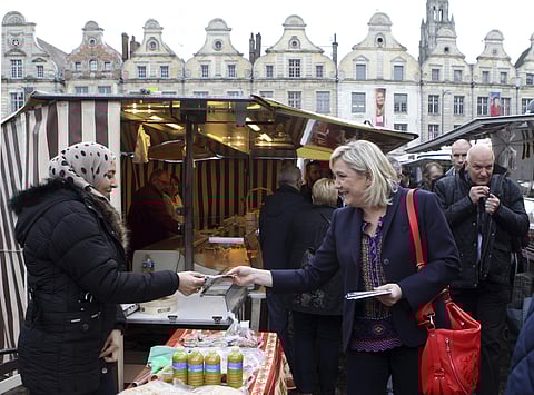 French far-right leader Marine Le Pen hands out leaflets in a marketplace, in Arras northern France, as part of her municipal campaign. (File Photo | AP)