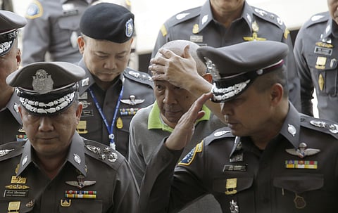 Ex Deputy secretary general of the Royal Household Bureau Jumpol Manmai, center, is escorted by Thai police officers upon arrival at the Crime Suppression Division in Bangkok,Thailand. (Photo | AP)