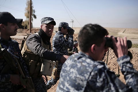Federal police officers look towards Islamic State group territory as civilians flee the area, in the town of Abu Saif, Iraq. Feb. 21, 2017.(File |AP)