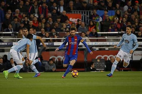 Barcelona's Lionel Messi, center, runs with the ball during a Spanish La Liga soccer match. (AP)