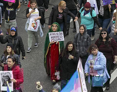 A woman dressed as Our Lady of Guadalupe, centre, holds a sign in Spanish, reading 'No Human Being is illegal,' in a march through  Los Angeles honouringtional Women's Day, Sunday, March 5, 2017. (Photo | AP)