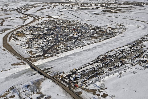 This aerial photo shows North Dakota Highway 1806, at left, where it crosses Cannonball River and Dakota Access pipeline protest camps on both sides of the river Monday, Feb. 13, 2017, in Cannon Ball, N.D. | AP