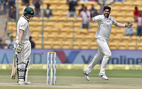 India's Umesh Yadav, right, celebrates the dismissal of Australia's captain Steven Smith, left, during the fourth day of their second test cricket match in Bangalore. (AP)