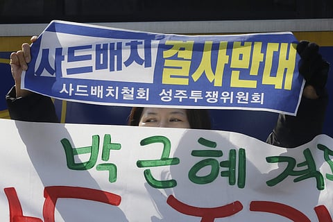 A protester holds up a banner during a rally to oppose the plan to deploy the Terminal High-Altitude Area Defense system, or THAAD, in front of the Defense Ministry in Seoul. (Photo | AP)